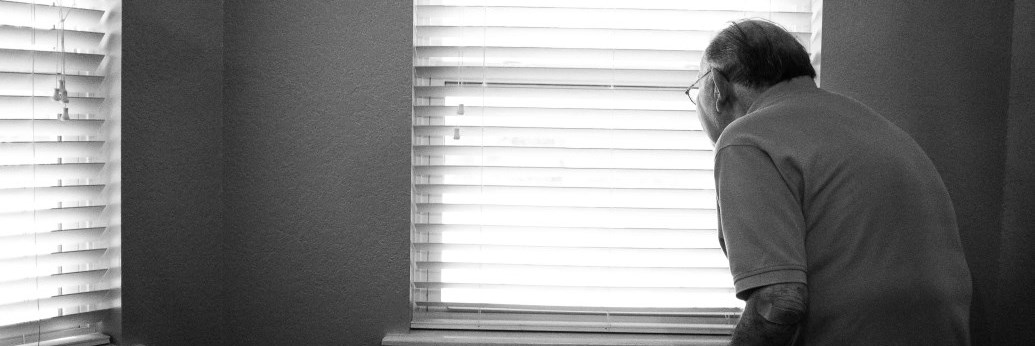 Elderly man in front of a window